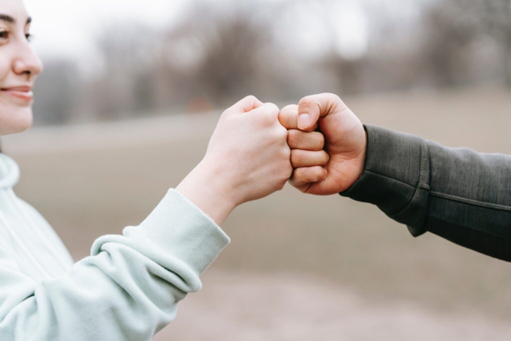 Image that a fist bump that illustrates healthy versus toxic relationships.